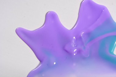 Colorful leaking paint liquid spills from close range