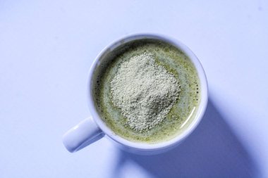Bir bardak sütlü matcha içeceği yakın.