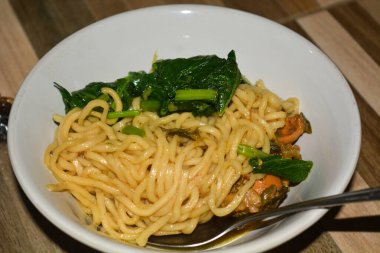 Tavuklu erişte çorbası, çay tabağı, kaşık ve peçete.