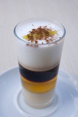 Geleneksel Kanarya kahvesi. Barraquito. Yoğunlaştırılmış süt katmanları ve bulanık arka planda likör..