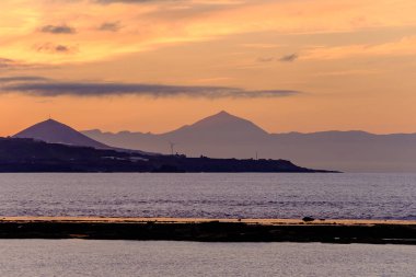 Teide volkanı ve Tenerife adasının Las Palmas de Gran Kanarya 'daki Las Canteras plajından gün batımında güzel manzarası..