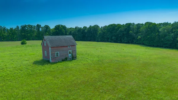 Вертикальный Снимок Зеленого Поля Одиноким Домом — стоковое фото