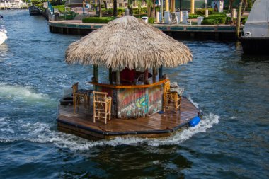 Ft. Lauderdale, Florida - February 2, 2023: Floating tiki bar cruises down the Intracoastal Waterway in Fort Lauderdale, Florida, USA. clipart