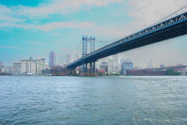 The new york city skyline with brooklyn bridge over a cloudy sky