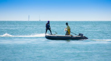 Turistlerin denizde sörf yaptığını görmek