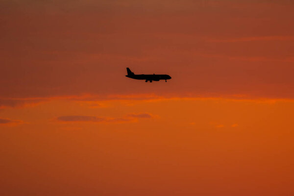Airplane in the sky of Miami Florida, USA at sunset