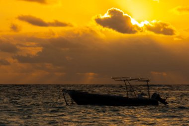 Punta Cana 'da gün doğumunda denizde küçük bir tekne.