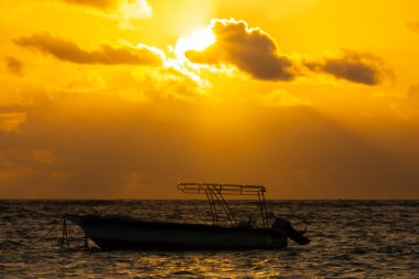 Punta Cana 'da gün doğumunda denizde küçük bir tekne.