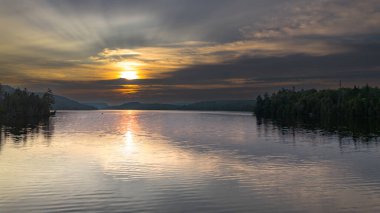 Gün batımının manzarası göl üzerinde dağlarda.