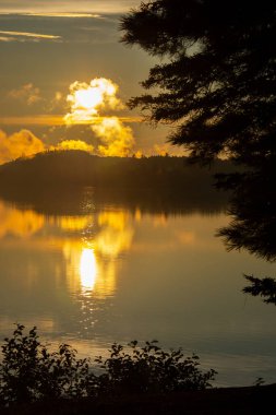 Kanada ormanında muhteşem bir balıkçı gölünün üzerinde gün batımı