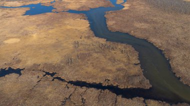 Dolambaçlı bir nehir ile manzaralı bir manzarayı vurgulayan bir hava manzarası.