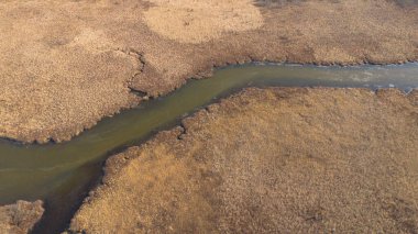 Dolambaçlı bir nehir ile manzaralı bir manzarayı vurgulayan bir hava manzarası.