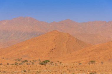 Uçurumların üstündeki mavi gökyüzü ve Fas 'taki kayalık Anti-Atlas dağları.