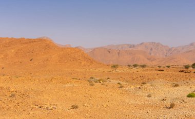 Uçurumların üstündeki mavi gökyüzü ve Fas 'taki kayalık Anti-Atlas dağları.