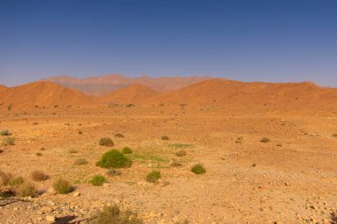 Uçurumların üstündeki mavi gökyüzü ve Fas 'taki kayalık Anti-Atlas dağları.