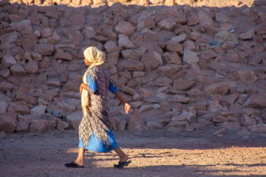 Sırt çantası yerde olan şapkalı bir kadın.