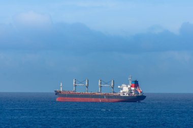 Mavi denizde güzel manzaralı bir kargo gemisi. 