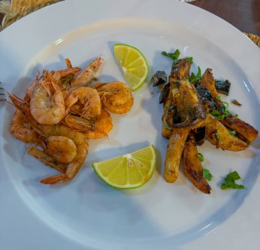 Beyaz tabakta limonlu kızarmış karides..