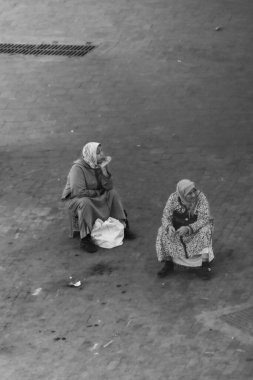İnsanlar sokakta oturuyor.