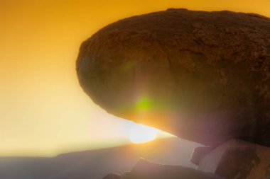 Gün batımında taşın üstünde 