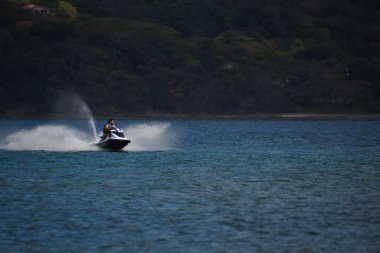 Baba ve oğlu nehirde jet scooter 'a biniyor.