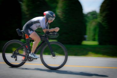Magog, Quebec, Kanada - 13 Temmuz 2025: Kanada 'nın Quebec kentinde düzenlenen uluslararası bir triatlon sırasında bisikletçi yolda