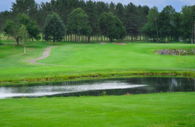 Golf sahasının ortasında bir gölet. 