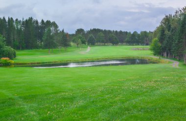 Golf sahasının ortasında bir gölet. 