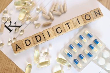 En üst düzey kelime bağımlılığı, ilaçlı beyaz kağıt üzerinde tahta küplerle toplanır. Bağımlılık rehabilitasyon kavramı
