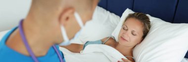 Doctor makes notes in patient card and examines patient in bed. Medical care and health insurance concept