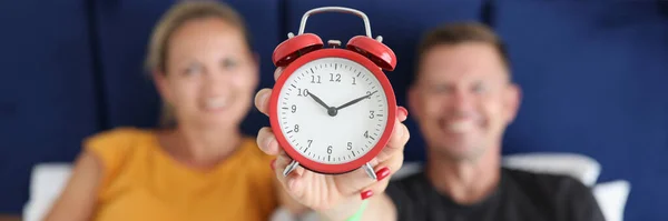 Smiling Man Woman Lying Bed Holding Alarm Clock Ten Oclock — Zdjęcie stockowe