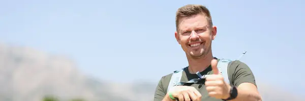 Smiling Man Holding Thumbs Holds Scandinavian Sticks Stands Mountain Benefits — Zdjęcie stockowe