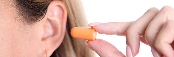 여성의 사진은 오렌지 귀마개를 삽입하고 실리콘 귀마개를 합니다 암컷은 시끄러운 — 스톡 사진