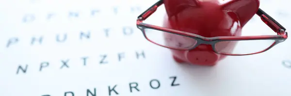 Närbild Röda Spargris Glasögon Ögonkontroll Styrelse Spara Pengar För Hälso — Stockfoto