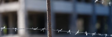 Barbed wire fence in front of prison building. Imprisonment concept