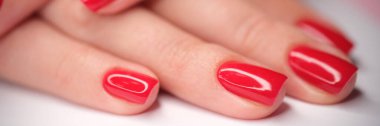Red bright beautiful varnish on female hands. Manicure nails concept