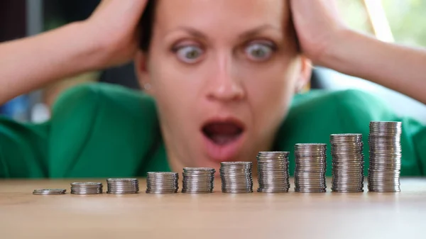 Zszokowana Zaskoczona Kobieta Patrzy Stosy Monet Stole Inflacja Rosnące Ceny — Zdjęcie stockowe