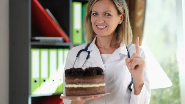 Женщина Врач Держит Руке Шоколадный Торт Напоминает Нездоровую Пищу Нутриционисты — стоковое фото