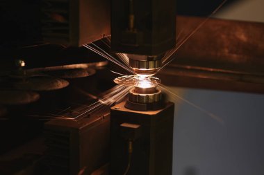 Alevler saçan metal kesme makinesine yakın çekim. Lazer kesme makinesi, metal levha ve ateşli parçacıklar. Üretim ve üretim kavramı