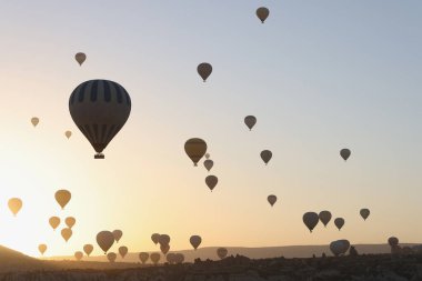 Gün batımında gökyüzünde sıcak hava balonlarının portresi. Popüler turizm aktivitesi, çevre konseptine inanılmaz bir bakış açısı