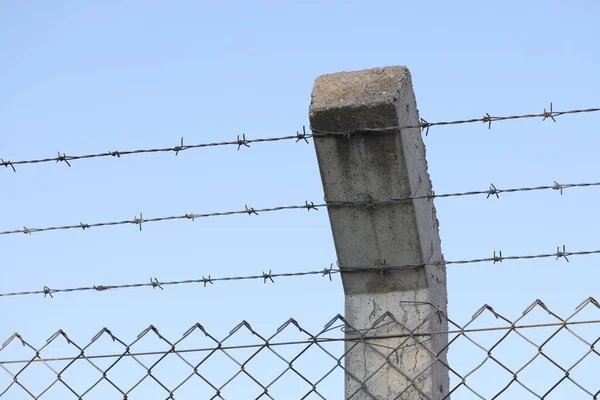 安全铁丝网围栏的特写 在混凝土柱子上用短短的尖尖尖刺组成的铁丝网 防患于未然 惩教机构概念 — 图库照片