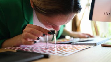 Kadın iç mimar, büyüteçten renk örneklerine bakıyor. Terfi için uygun renk arayan bir kadın. Tasarım konsepti