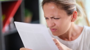 Konsantre kadın portresi daha net görebilmek için gözlerini kısarak gazete okuyor. Metni görmekte güçlük çeken kadın, görme sorunları