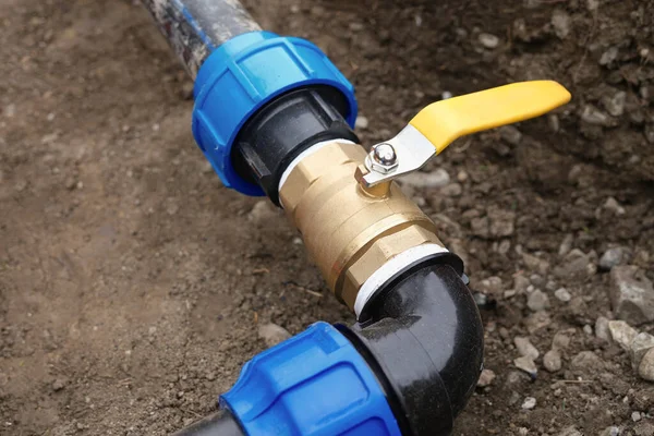 黄色のタップや蛇口に合う肘で地下灌漑システムのクローズアップ 排水設備の配管 — ストック写真