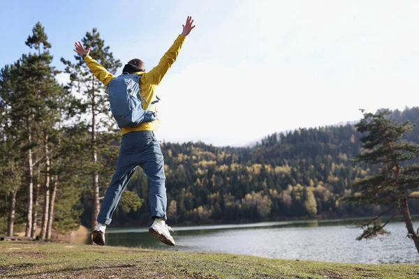 Feliz Viajero Masculino Saltando Cerca Hermosa Vista Posterior Del Lago — Foto de Stock