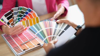 Yönetici, müşterinin ofisteki çeşitli örneklerden renk seçmesine yardımcı olur. Sanat stüdyosundaki renk seçim sürecinin kapatılması.