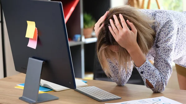 職場でのミスや問題により 従業員は苦しんでいます 女性取得彼女の頭とともに彼女の手でコンピュータの前にテーブルの上 — ストック写真