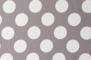 Gray and white fabric with polka dot pattern. Textile with white circles on gray background.