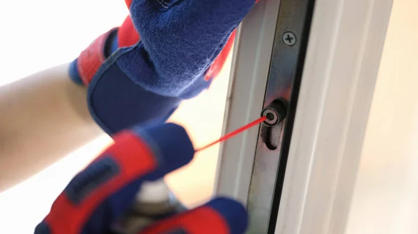 Repairman fixes window closing problem. Handyman in gloves serves windows of customers close up.