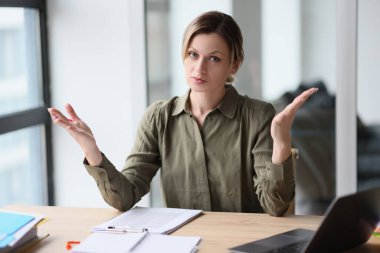 The young woman in the office divorced her hands in bewilderment, a close-up. Problem at work, gesture